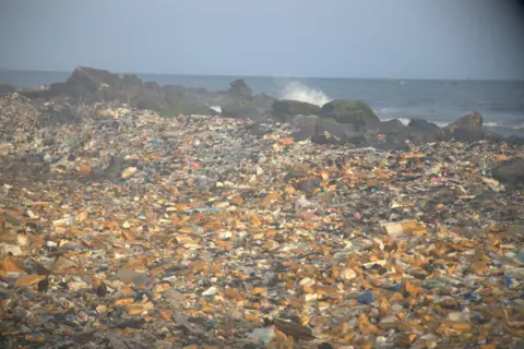 Plastik dan sisa lain termasuk dari e-waste dihanyutkan kembali di tepi laut di kawasan tepi laut Jamestown di Accra