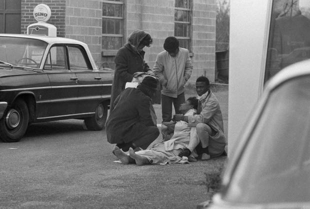   Amelia Boynton dibantu oleh orang ramai selepas dia cedera apabila polis negeri memecahkan perarakan tunjuk perasaan Boynton membantu memimpin di Jambatan Edmund Pettus