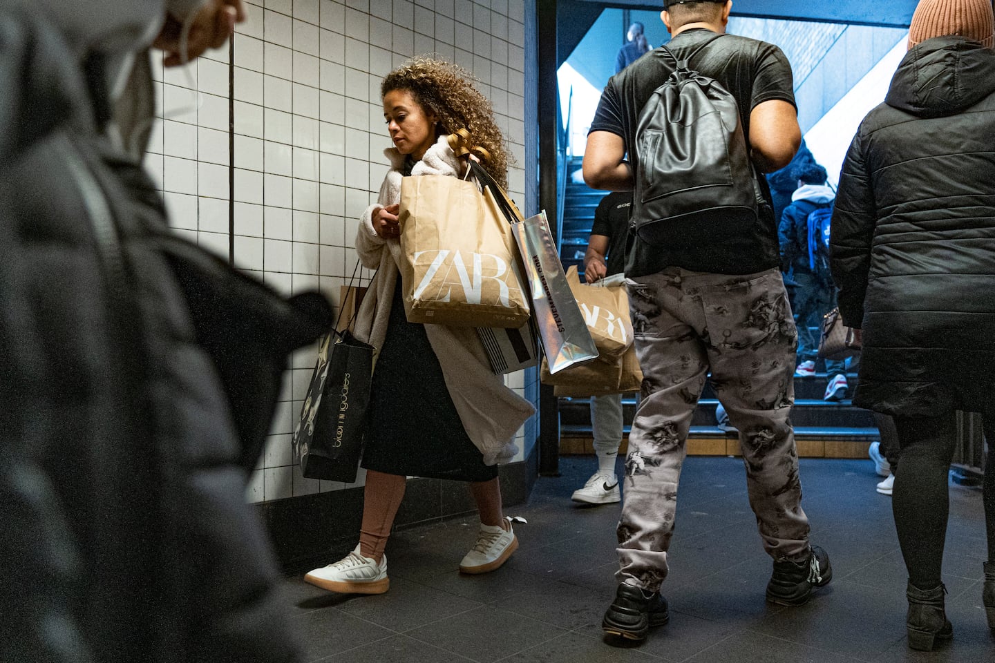 Seorang wanita dengan beg membeli-belah memasuki stesen kereta api bawah tanah Broadway-Lafayette Street pada Black Friday di New York City, 24 November 2023.