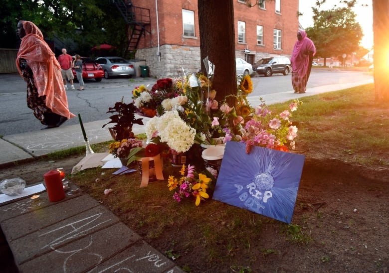 Orang yang berkabung di bunga pas peringatan diletakkan di luar apartmen tempat Abdirahman Abdi tinggal dan maut ditembak Ahad selepas ditangkap oleh polis Ottawa, Selasa, 26 Julai 2016, di Ottawa. 