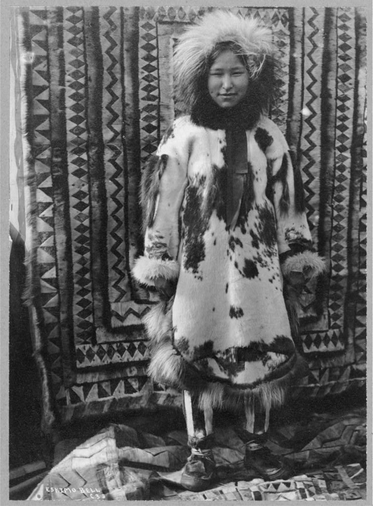 gambar dari tahun 1900-an menunjukkan seorang gadis Inuit berpakaian pelbagai bulu dan kulit untuk cuaca sejuk.