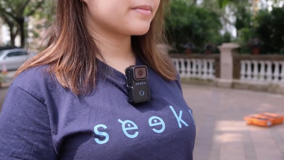     Seorang lelaki dengan kamera Seekr melekat pada baju-Tnya. 