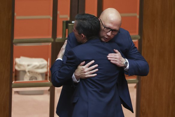 Simon Birmingham dan Peter Dutton berpelukan selepas yang pertama mengumumkan persaraannya daripada politik.